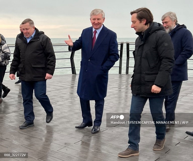 Foto selebaran ini diambil dan dirilis oleh perusahaan System Capital Management (SCM) pada 16 Februari 2022, menunjukkan oligarki Ukraina Rinat Akhmetov (tengah) dan pengusaha Vadim Novinsky (kanan) berjalan di sepanjang tepi laut di Mariupol. Secara simbolis, beberapa orang kaya Ukraina mengumumkan kepulangan mereka ke negara itu setelah mendapat telepon dari Kepala Negara. Orang terkaya Ukraina, oligarki Rinat Akhmetov, melakukan perjalanan ke Mariupol mengumumkan lebih dari 1 miliar dollar AS investasi di sana untuk tahun 2022.